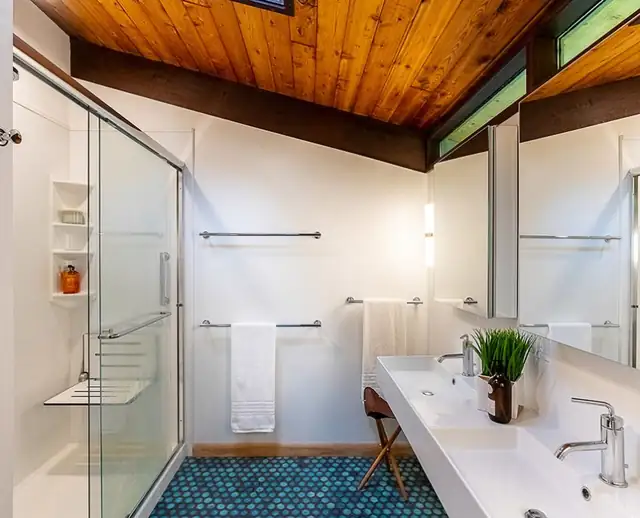 Barrington, RI mid-century bathroom with a wood plank ceiling, blue penny tile floor, glass shower and white trough sink